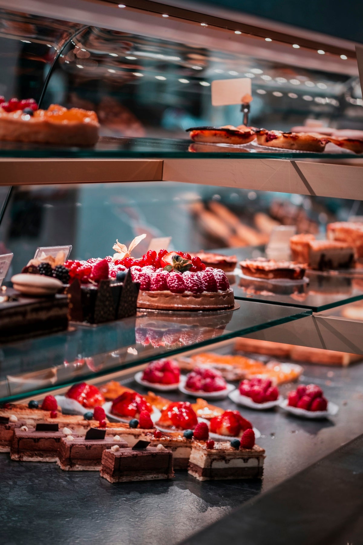 strawberry and blackberry on clear glass display counter