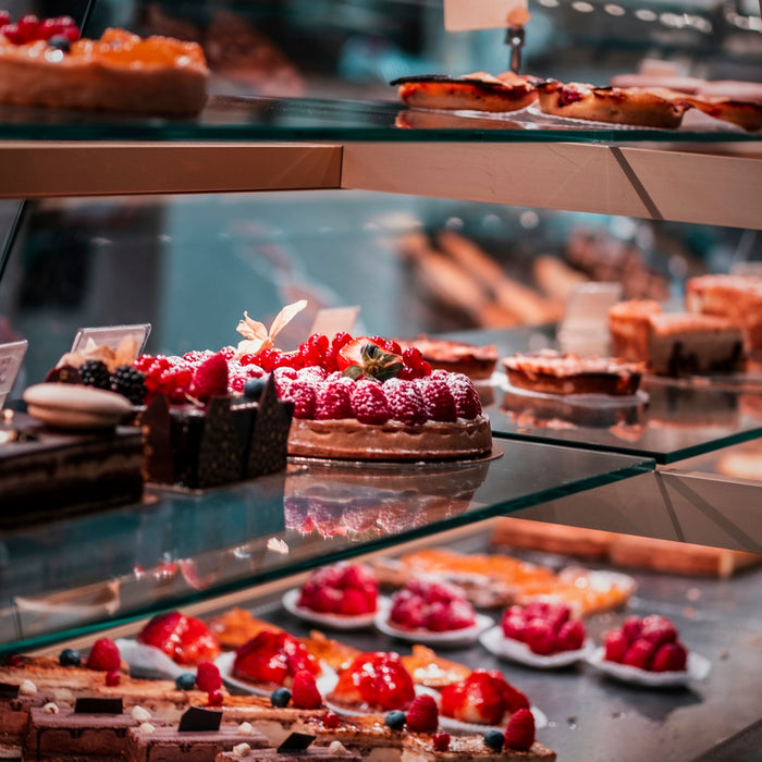 strawberry and blackberry on clear glass display counter