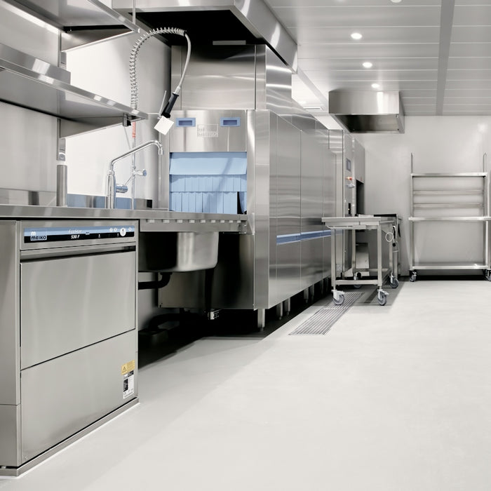 A commercial kitchen with stainless steel dishwashing equipment and metal shelving units