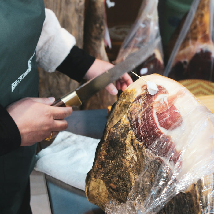 person slicing meat on table