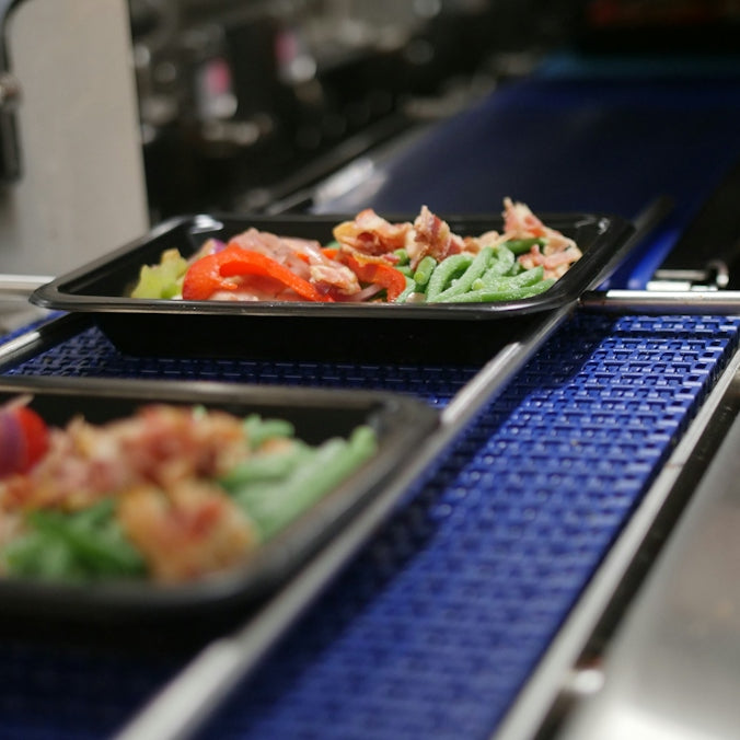 a couple of trays of food on a stove