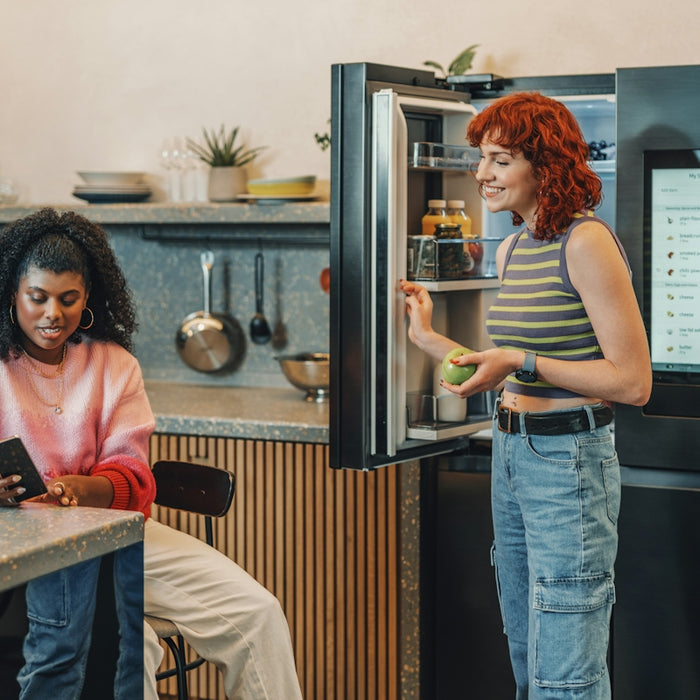 a person standing next to a person sitting at a table