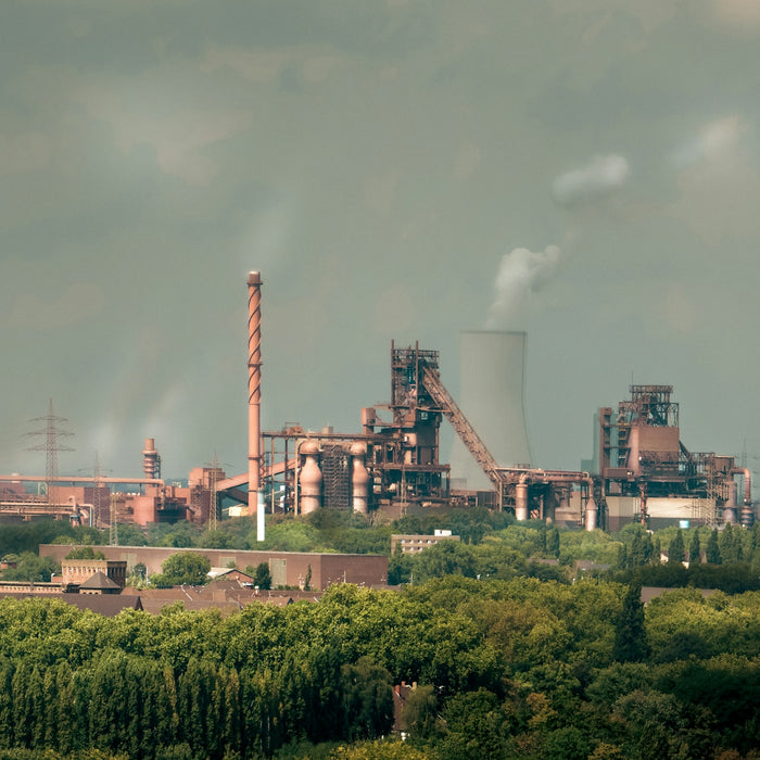 Industrial factory with smokestacks and cooling tower.